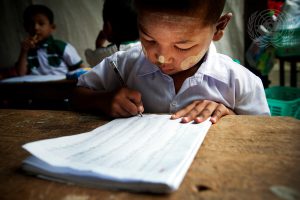 A child practices his writing during a kindergarten class in Myanmar.